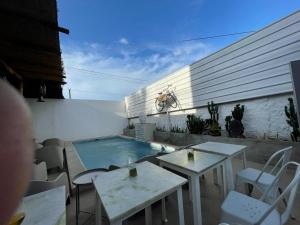 eine Terrasse mit 2 Tischen und einem Pool in der Unterkunft Ossoma House in Luanda