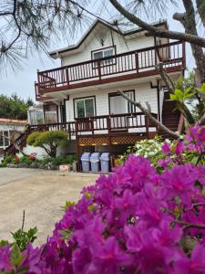 仁川的住宿－Ganghwa Sweet House Pension，前面有紫色花的房屋