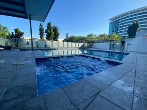 a swimming pool on the roof of a building at Spacious River view 3 Bdrm Apt with 2 Car spaces in Brisbane