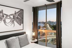 a bedroom with a bed and a large window at Spacious River view 3 Bdrm Apt with 2 Car spaces in Brisbane
