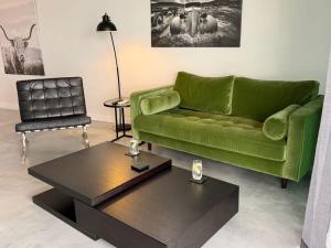 a green couch and a coffee table in a living room at Spacious River view 3 Bdrm Apt with 2 Car spaces in Brisbane