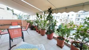 a balcony with potted plants and a table and chairs at Cozy home in Kypseli in Athens