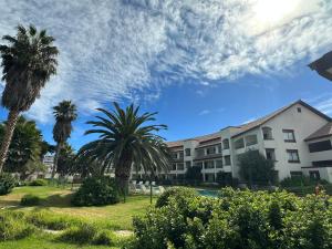 edifício aominium com palmeiras em frente a um edifício em Hotel Palmas de La Serena em La Serena