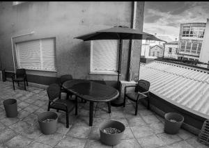 a table and chairs and an umbrella on a balcony at Apartamento A Casa De Silvia in Padrón
