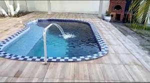 uma pequena piscina com uma fonte de água em Casa Duplex na Praia de Catuama em Ponta do Funil
