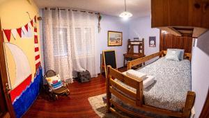 a bedroom with a bed and a crib in it at Apartamento A Casa De Silvia in Padrón