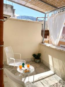małe patio ze stołem i krzesłami na balkonie w obiekcie Conte125 w mieście Cinisi