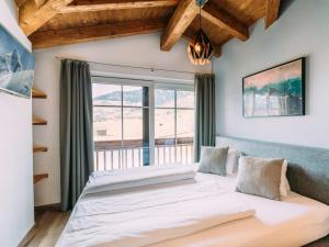 ein Schlafzimmer mit einem großen Bett mit Fenster in der Unterkunft Tauern Lodge L in Piesendorf
