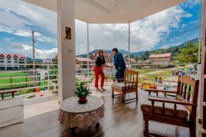 two people standing on a balcony looking out of a window at Las Yungas Hospedaje in Oxapampa