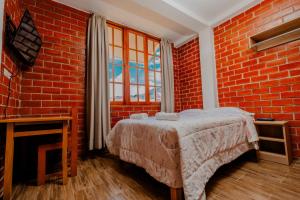 - une chambre avec un lit dans un mur en briques dans l'établissement Las Yungas Hospedaje, à Oxapampa