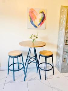 a table and two stools in a room with a painting at FLiXBEDS - The Latinx MIA Airport- Downtown - Casino - Wynwood in Miami