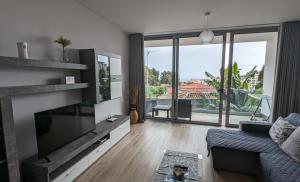 a living room with a large flat screen tv at Sol do Til Apartment in Funchal