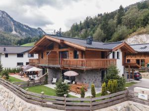 una gran casa de madera con una valla delante de ella en Lodge Elise en Wald im Pinzgau