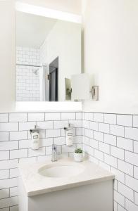 Baño blanco con lavabo y espejo en The Gregorian New York City en Nueva York
