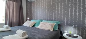 a bedroom with a bed with blue and white pillows at LA MARCELINO in Patagones