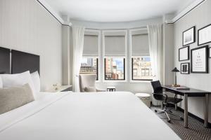 een slaapkamer met een groot wit bed en een bureau bij The Gregorian New York City in New York