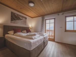 um quarto com 2 camas e uma grande janela em Bella Vista XL em Wald im Pinzgau