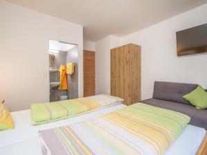 ザールバッハ・ヒンターグレムにあるRupertihof IIのベッドルーム1室(ベッド2台、壁掛けテレビ付)