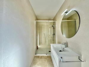 Baño blanco con lavabo y espejo en Vivienda Real 19 en Úbeda