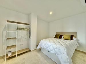 a white bedroom with a bed and a closet at Vivienda Real 19 in Úbeda