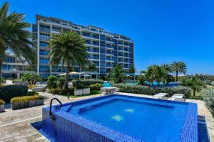 a swimming pool in front of a hotel at Azure 515 Aruba Vacation Sunset Breeze in Palm-Eagle Beach