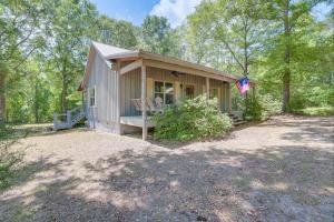 a small house with a porch and an american flag at Charming Lawley Cottage: Deck, Fire Pit & Yard! in Lawley