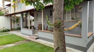 a house with a yellow rope tied to a tree at Casa Rústica no centro de Araruama in Araruama