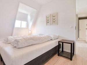 um quarto branco com uma cama e uma mesa em t Kaatsheuveltje 5 em Kaatsheuvel