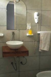 W łazience znajduje się umywalka i lustro. w obiekcie Hotel Sienna w mieście Mendoza