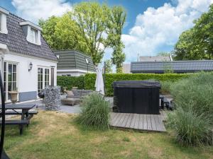 a backyard with a patio with a table and benches at t Kaatsheuveltje 5 in Kaatsheuvel