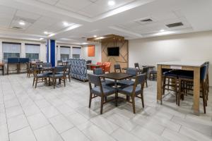 a waiting room with tables and chairs and a tv at Holiday Inn Express Hotel & Suites Freeport, an IHG Hotel in Freeport