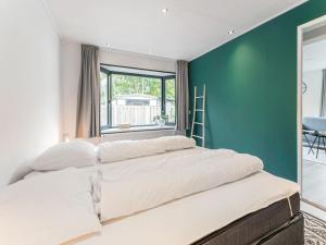 un grande letto in una stanza con parete verde di t Kaatsheuveltje 6 a Kaatsheuvel