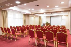a room with rows of chairs and a podium at Ramada Iasi City Center in Iaşi