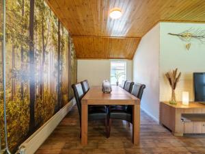 uma sala de jantar com uma mesa de madeira e cadeiras em Achter de Vijf Linden em Knegsel
