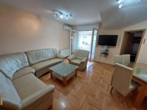 ein Wohnzimmer mit einem Sofa und einem Tisch in der Unterkunft Index Apartman in Banja Luka