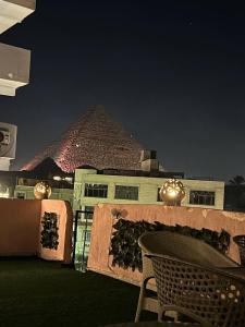 een patio met een tafel en een piramide op de achtergrond bij Beko pyramids hotel in Caïro