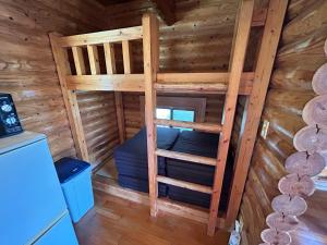 a room in a log cabin with a bunk bed at Tokashiki Guest House in Tokashiki