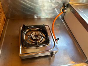 a dog with an orange cord plugged into a stove at Tokashiki Guest House in Tokashiki
