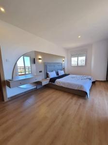 a large bedroom with a bed and a large window at Très beaux F4 Annaba in Zonka