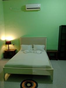 a bed with white sheets and pillows in a room at Greenbury Kite Hostel & Restaurant in Kalpitiya +39 photos