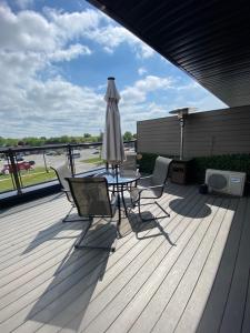 a patio with a table and an umbrella on a deck at Rooftop getaway Niagara in Niagara Falls
