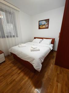 a bedroom with a large bed with two towels on it at Serenity at Sveti Stefan in Sveti Stefan