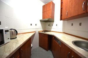 a small kitchen with wooden cabinets and a sink at Serenity at Sveti Stefan in Sveti Stefan
