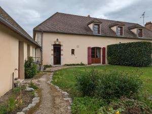 a white house with a red door and a yard at Maison de caractère avec jardin privatif, terrasse, ping-pong – Proche Ferrières et Montargis - FR-1-590-40 in Lorcy