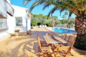 un patio con mesa y sillas junto a una piscina en Albertina - private pool villa, free Wifi, in Benissa, en Benissa