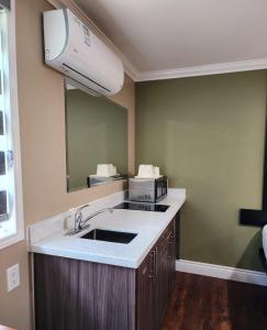 a kitchen with a sink and a large mirror at Super 8 by Wyndham Pembroke in Pembroke