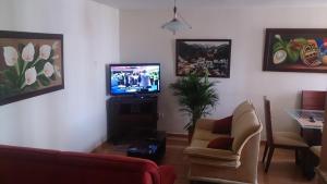 sala de estar con sofá y TV en Apartamento Los Delfines del Caribe, en Cartagena de Indias