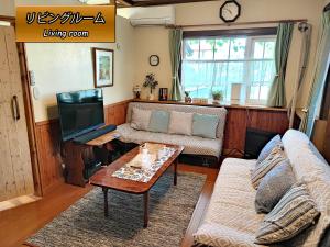 sala de estar con sofá y mesa en Folks House, en Eniwa