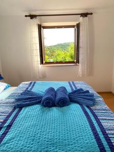 a bed with blue towels on it with a window at Family friendly house with a swimming pool Krmed, Central Istria - Sredisnja Istra - 23175 in Bale +24 photos