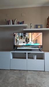 una sala de estar con TV en un centro de entretenimiento blanco en Apartamento en la Ciudad de las Artes y las Ciencias, en Valencia